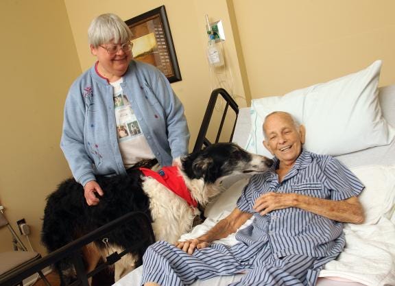 Tina Whisnant and her certified therapy dog, Denzel, a 5-year-old Russian Wolfhound, visit with Hospice patient Bill Stroud at Wendover Hospice House in Shelby. Whisnant and Denzel will lead an upcoming Pet Loss Workshop sponsored by Hospice.