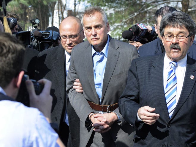 Former sportscaster Don Tollefson (center) heads into the District Court in Warminster in handcuffs with his lawyers after turning himself in on Tuesday morning.