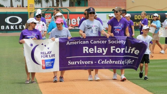 Cancer survivors participate in a lap during last year’s inaugural American Cancer Society Relay for Life of Jupiter event at Roger Dean Stadium in Jupiter.