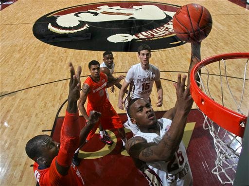 Florida State guard Aaron Thomas (25) makes a layup over the defense of Syracuse center Baye Moussa Keita, left, in the first half of an NCAA college basketball game on Sunday, March 9, 2014, in Tallahassee, Fla. Syracuse defeated Florida State 74-58. (AP Photo/Phil Sears)
