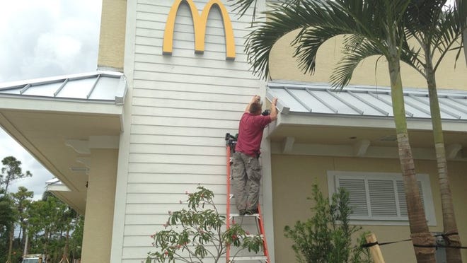 A construction worker puts the finishing touches on the new McDonald’s that opened March 27 off Orange Boulevard and Seminole Pratt Whitney Road in Loxahatchee. (Kristen M. Daum / The Palm Beach Post)