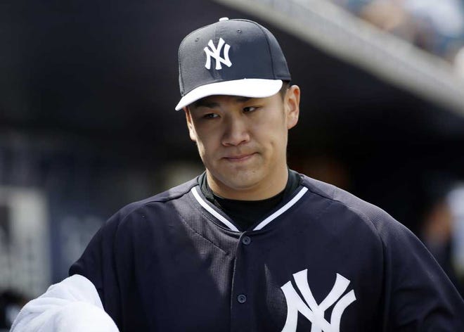New York Yankees starting pitcher Masahiro Tanaka walks with a towel on his pitching arm during a spring exhibition baseball game against the Atlanta Braves in Tampa, Fla., Sunday, March 16, 2014. (AP Photo/Kathy Willens)