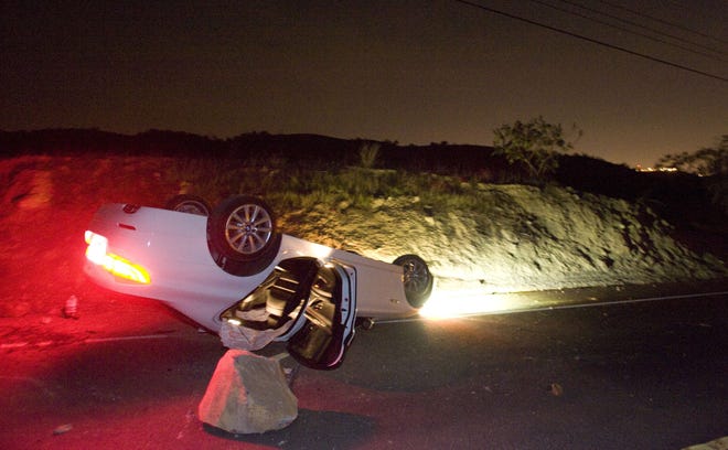 A car sits rolled over in the wake of Friday nights March 28, 2014 earthquake on Carbon Canyon Road in Brea, Calif., near Olinda Village. (AP Photo/The Orange County Register, Rod Veal)