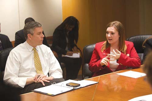 Arne Duncan, United States Secretary of Education, listens to Daria Ferdine, a senior at Sussex County Technical School, as she speaks about her high school experience.