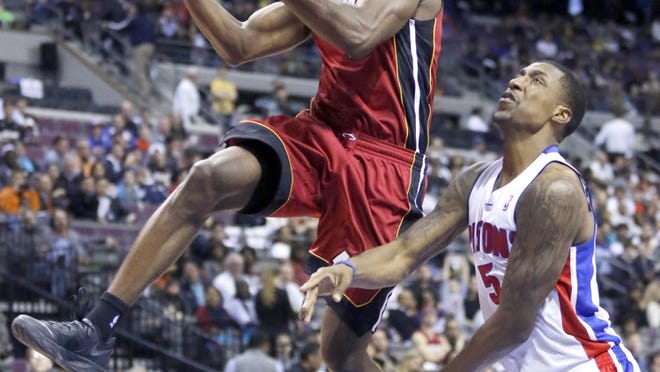 Miami Heat guard Toney Douglas, left, goes to the basket against Detroit Pistons guard Kentavious Caldwell-Pope (5) during the second half of an NBA basketball game on Friday, March 28, 2014, in Auburn Hills, Mich. The Heat defeated the Pistons 110-78. (AP Photo/Duane Burleson)