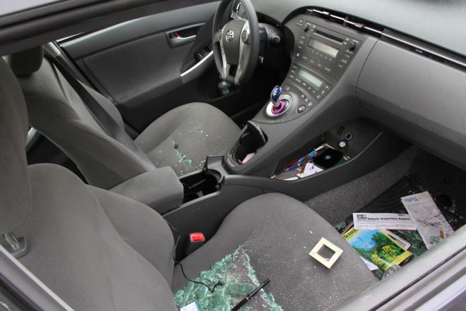 Broken glass fills the front passenger seat of Michelle Kwan's Prius, at State Towing Service, in Providence, on Friday. The car was found in North Providence Thursday night.