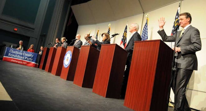 The U.S. Senate candidates, standing from left, Phil Gingrey, Jack Kingson, Art Gardner, Derrick Grayson, Karen Handel, Paul Broun and David Perdue, are introduced to the audience at Savannah Arts Academy Saturday evening. (Carl Elmore/For the Savannah Morning News)