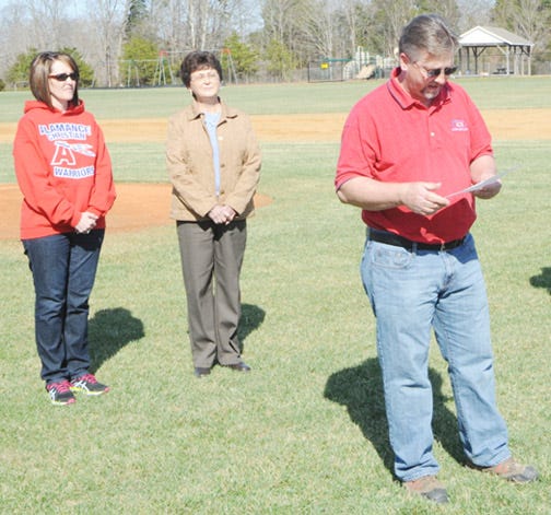 Anita Robinson, left, and Linda Miles take part in on-field ceremony as Kim Ingle, a former coach with the ACS baseball program, shares thoughts during the field dedication.