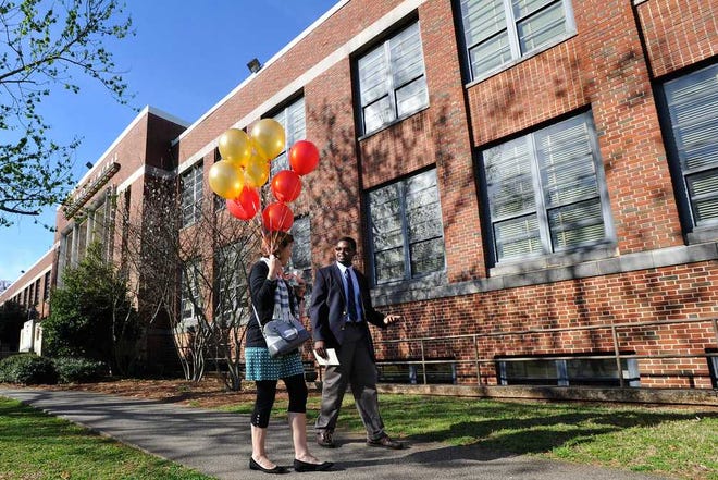 Katherine Downs, left, and Lawrence Harris talk while carrying balloons away from a ceremonial groundbreaking ceremony for a renovation project at Clarke Central High School in Athens, Ga., Monday, March 31, 2014. (AJ Reynolds/Staff, @ajreynoldsphoto)