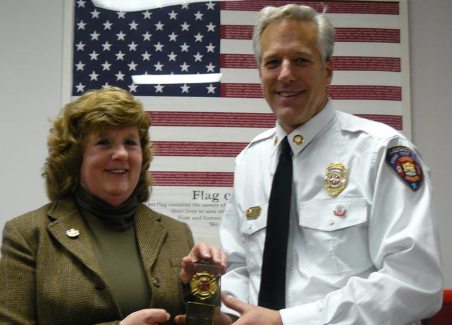 Jane Verplank, chairwoman of the Saugatuck Township Fire District, receives an award for her service from Fire Chief Greg Janik at a recent ceremony. The award reads: ìFor your continued and unrelenting support of the firefighters of Saugatuck Township Fire District from the chief and fire officers.î Contributed