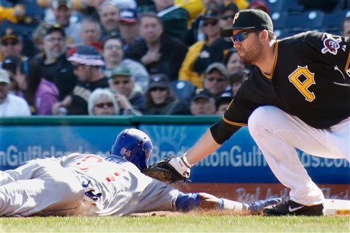 Pittsburgh Pirates first baseman Travis Ishikawa, right, reaches to tag Chicago Cubs Emilio Bonifacio as he dives back to first on a pickoff attempt in the tenth inning the opening day baseball game on Monday in Pittsburgh. The Pirates won 1-0 in ten innings.