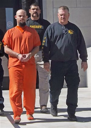 In this March 14, 2014 photo, James Paul Harris, left, is escorted from the Osage County Courthouse in Lyndon, Kan. Harris who is accused of beheading James Gerety with a guitar string three years ago and keeping his head as part of a Voodoo ritual, pleaded not guilty to premeditated first-degree murder Monday, March 31. (AP Photo/The Topeka Capital-Journal, Steve Fry)