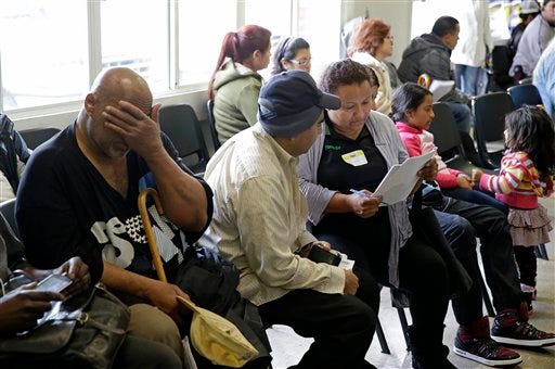 FILE - This March 31, 2014 file photo shows applicants waiting to be called during a health care enrollment event at the Bay Area Rescue Mission in Richmond, Calif. It's not too late to get covered. A few routes remain open for those who missed the health care law's big enrollment deadline. Millions may be eligible for a second chance to sign up for subsidized insurance. And people who get coverage after the deadline can still avoid, or at least reduce, the fine for going uninsured. (AP Photo/Eric Risberg, File)
