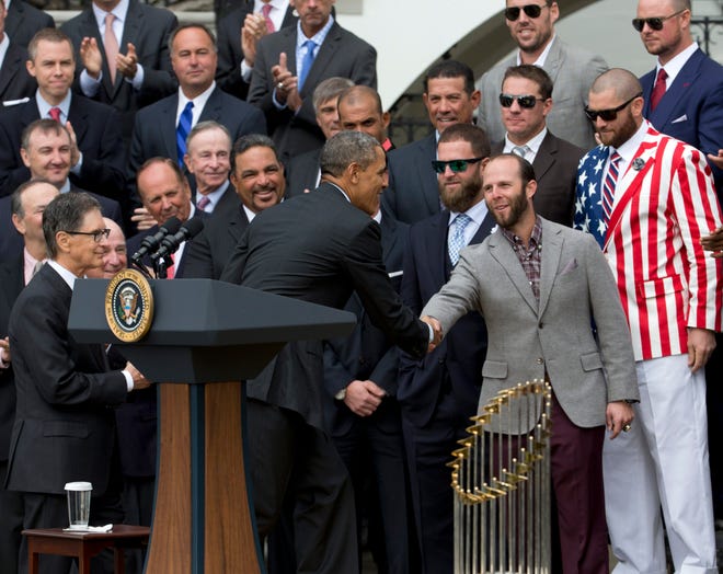 President Barack Obama shakes hands with Red Sox second baseman Dustin Pedroia during a ceremony to honor the 2013 World Series champions on the South Lawn of the White House on Tuesday. Oufielder Jonny Gomes, sporting an American flag jacket, is to Pedroia's right.