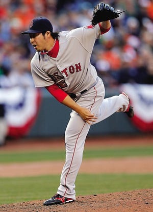 Boston Red Sox relief pitcher Junichi Tazawa follows through on a pitch to the Baltimore Orioles in the eighth inning of their opening day baseball game Monday in Baltimore. The Red Sox lost, 2-1.