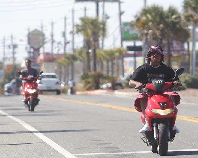 Passengers ride scooters along Front Beach Road on Monday. Bay County and Panama City Beach officials are developing a uniform policy on moped, scoot car, scooter and motorcycle rentals.