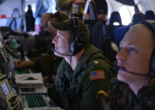 Lt. Cmdr. Mike Trumbull, a naval flight officer assigned to VP-16, monitors his workstation March 24 in a P-8A Poseidon during a mission to assist in search and recovery operations for Malaysia Airlines Flight MH370.