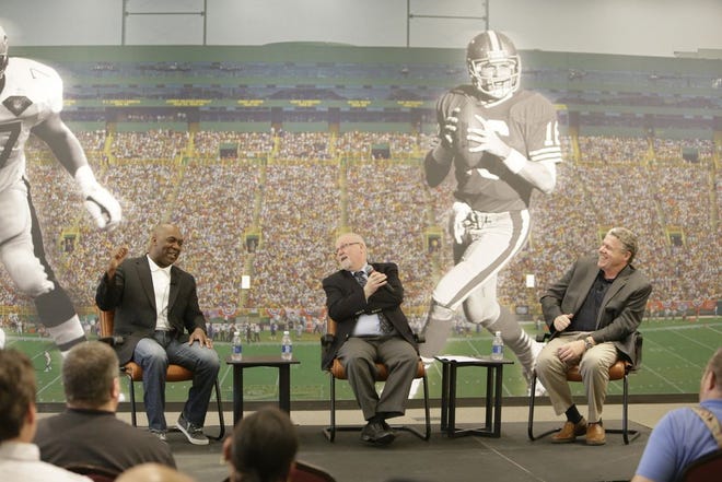Pro Football Hall of Fame member Thurman Thomas (left) tells a story during a round-table discussion with Hall vice president Joe Horrigan Vice President and sportswriter Peter King (right) on Wednesday night.