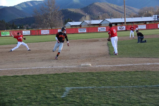Cade Parker of Yreka runs to third base while Andrew Stone of Etna throws to first base during game action on Wednesday night in Yreka. Daily News Photo/Bill Choy