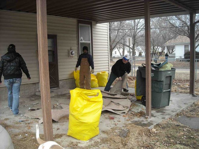 Community members in March clean a yard Councilman John Campos II said had been ignored by the city of Topeka.