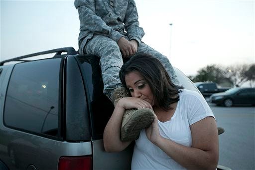 Lucy Hamlin leans on her husband's foot, Specialist Timothy Hamlin, as they wait to be allowed back onto Fort Hood, Texas, where they reside on Wednesday, April 2, 2014. A shooting occurred on the base with at least four dead and 14 injured according to the officials.