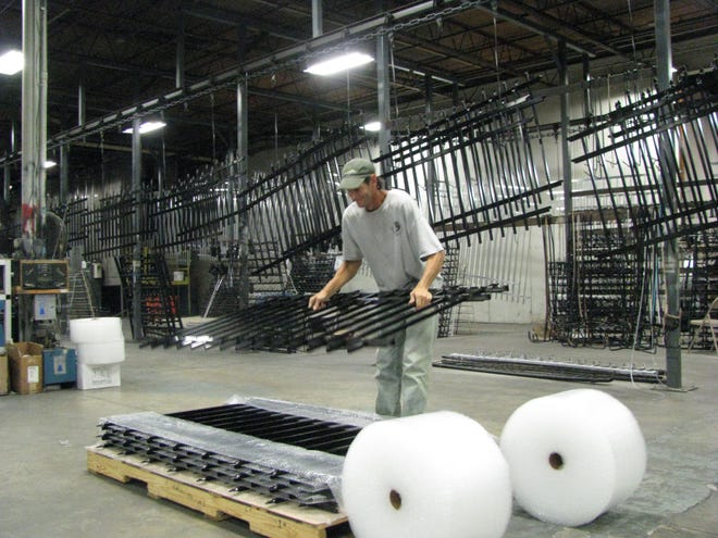 Wade Schmitz pulls a section of powder-coated fence secion off the line and stacks them for shipping at iDeal Aluminum Products in DeLand. The company’s owners this week announced plans to move to St. Johns County by year’s end.