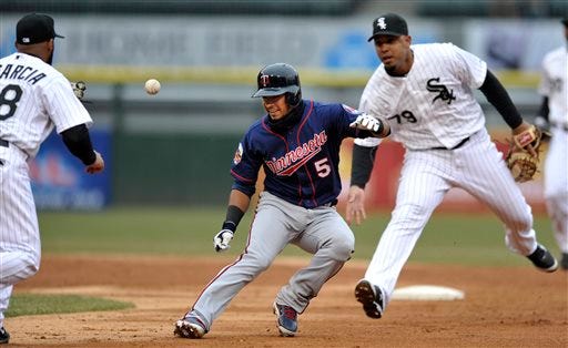Minnesota Twins' Eduardo Escobar (5) is caught in a rundown between second base and first base by Chicago White Sox's Jose Abreu (79) and Leury Garcia (28) during the third inning of a baseball game in Chicago, Thursday, April 3, 2014. Minnesota won 10-9. (AP Photo/Paul Beaty)