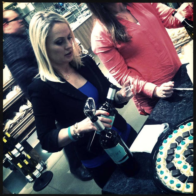 Cindy Sebek pours a sample of wine on Thursday at Market Street in Lubbock. United announced a partnership on Thursday with The Gracious Gift Wine. For each bottle of wine sold, four meals will be given to the South Plains Food Bank. (Zach Long)