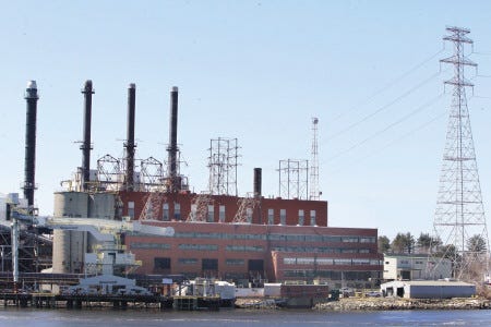 Public Service Company of New Hampshire’s Schiller fossil fuel plant is seen on the banks of the Piscataqua River Thursday in Portsmouth. A report released this week says that in the long term, PSNH customers would be better off if the company divested itself of its three fossil fuel plants and nine hydroelectric generators.