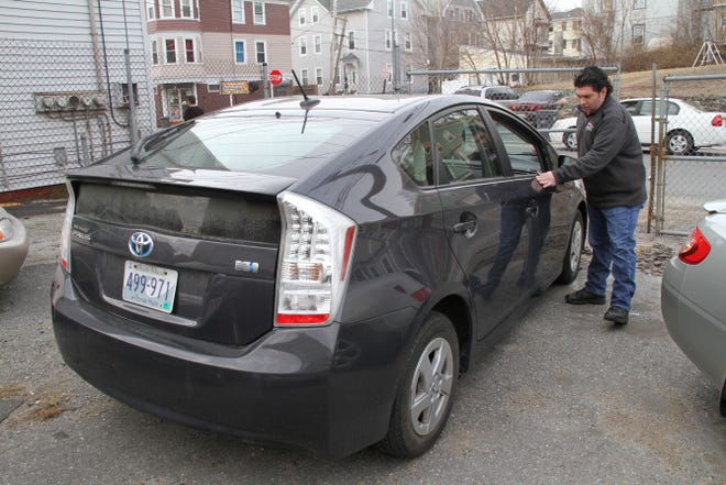 Michael Salvatore, owner of State Towing Service, in Providence, checks the damage to the missing Prius owned by Clay Pell and Michelle Kwan on Friday.