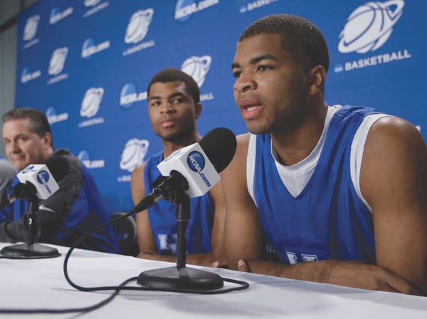 Kentucky’s Aaron Harrison answers a question at a press conference March 29 while his twin brother, Andrew, and coach John Calipari look on. (David J. Phillip | Associated Press)