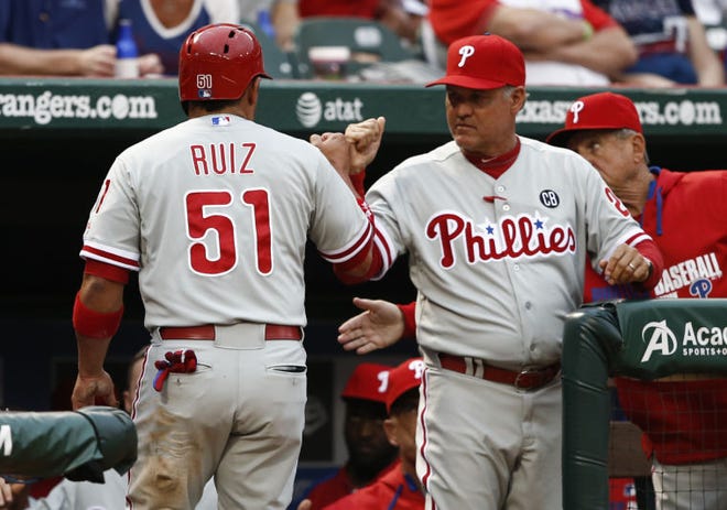 Philadelphia's Carlos Ruiz is congratulated by manager Ryne Sandberg after scoring a run against the Rangers during the first inning of Wednesday's game in Arlington, Texas.