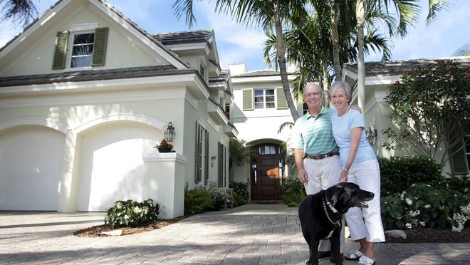 Frank and Mary Jo Murphy with their dog Sweetpea in front of their 3,700-square-foot home in the Loxahatchee Club community in Jupiter. The couple moved to Jupiter three and a half months ago from Kiawah Island, South Carolina. (Bill Ingram / Palm Beach Post)