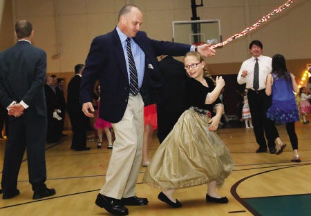 Tom Bake spins his daughter, Anya Bake, 8, at the annual Father-Daughter Dance hosted by Girl Scout Troop 22401 at Greenland Central School on Saturday.