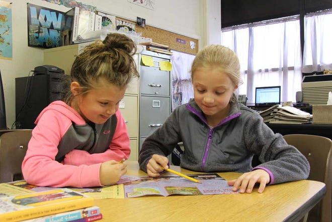 Ava Simmons, left, and Lauren Brown read an article on Yosemite National Park in Todd Gish's second-grade class at Valley Falls Elementary.