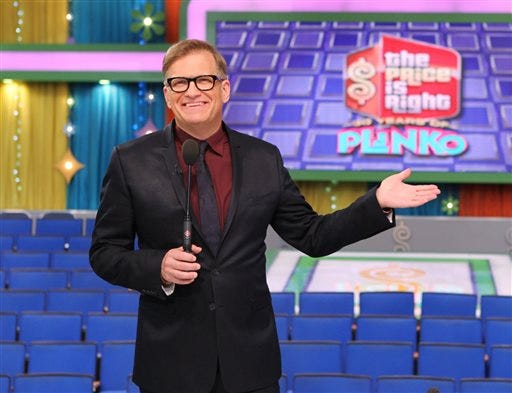 This 2013 photo released by CBS shows Drew Carey, host of "The Price is Right," on the set in Los Angeles. On Tuesday, April 7, the game show will air its 8,000th episode since it debuted on CBS in 1972. The concept hasn't changed through the years and it's a nonstop party in the hands of host Drew Carey. (AP Photo/CBS, Cliff Lipson)
