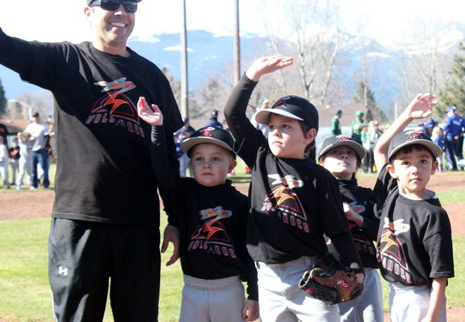Coach John Kennedy and members of his Volcanoes T-Ball team wave to the crowd Saturday morning during Opening Ceremonies for the 2014 season in south Siskiyou County.