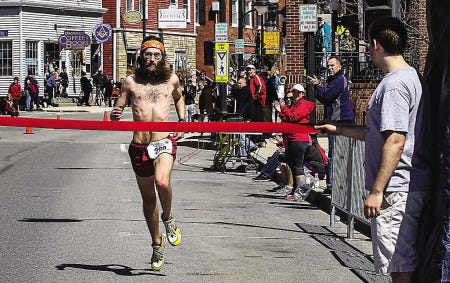 Great Bay Half Marathon winner Derrick Hamel of Northwood crosses the finish line on Main Street in Newmarket on Sunday. Nearly 1,200 runners competed in the half marathon and 5K races.