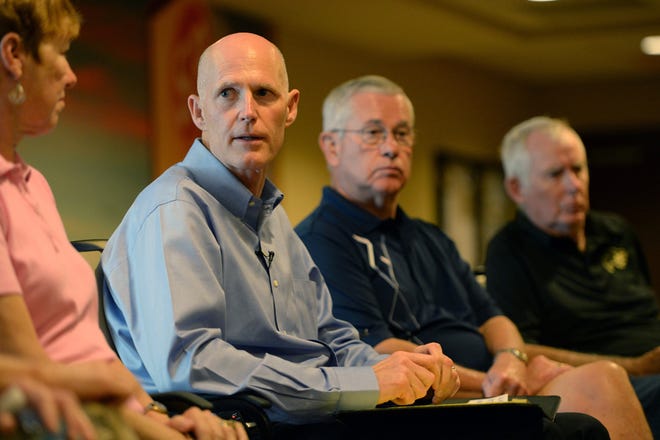 Florida Gov. Rick Scott visits Sumter Place, an assisted living facility, to talk with people about their concerns regarding the Affordable Care Act in The Villages on Wednesday.