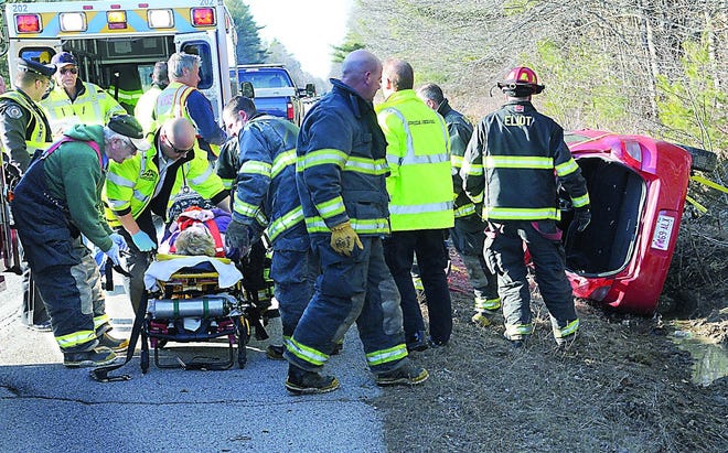 A woman was removed from an overturned vehicle after a crash on Route 236 in Eliot and brought to a hospital during rush hour traffic.