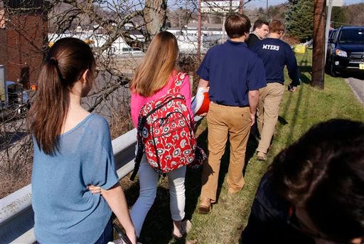 Students leave the campus of the Franklin Regional School District where several people were stabbed at Franklin Regional High School on Wednesday, April 9, 2014, in Murrysville, Pa., near Pittsburgh. The suspect, a male student, was taken into custody and being questioned. (AP Photo/Gene Puskar)