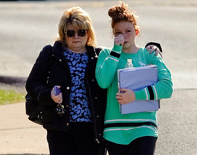 A student and guardian walk to their car from Franklin Regional Middle School after more then a dozen students were stabbed by a knife-wielding suspect at nearby Franklin Regional High School on Wednesday in Murrysville, Pa., near Pittsburgh.