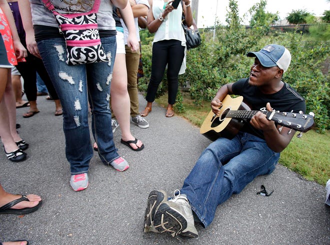 C.J. Harris sings a tune while waiting in line to audition for "American Idol" at the Tuscaloosa Amphitheater on Aug. 21, 2013. Harris is one of three contestants from Alabama who have made it into the top eight.