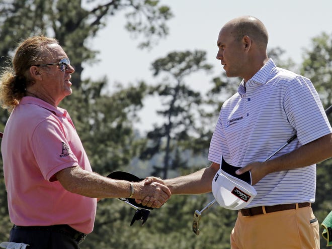 Miguel Angel Jimenez, of Spain, shakes hands with Bill Haas, right, on the 18th green following their first round of the Masters on Thursday in Augusta, Ga.