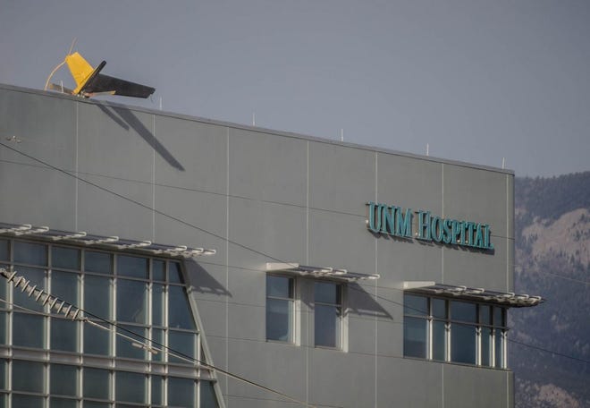 A helicopter's tail hangs over the edge of the UNM Hospital Wednesday afternoon, April 9, 2014, when it crashed as it took off from the roof of the building.  (AP Photo/The Albuquerque Journal, Roberto E. Rosales) THE SANTA FE NEW MEXICAN OUT