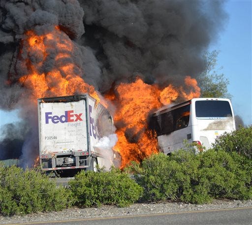 Massive flames engulf a tractor-trailer and a tour bus just after they collide on Interstate 5, Thursday, April, 10, 2014, near Orland, Calif. At least 10 people were killed in the crash, authorities said. (AP Photo/Jeremy Lockett)