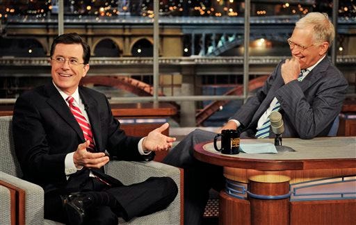 In this May 3, 2012 photo provided by CBS, Stephen Colbert, left, host of the “Colbert Report” on the Comedy Central Network, has a laugh on stage with host David Letterman on the set of the “Late Show with David Letterman,” in New York. CBS announced on Thursday, April 10, 2014 that Colbert will replace Letterman as “Late Show” host after Letterman retires in 2015.
