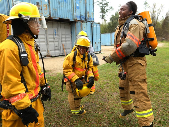 Juliette Smith, 18, a senior in the Loften High School Academy of Fire Emergency Medical Services, jumps while trying to tighten her belt before a training exercise at the school on March 19. At far left is Andy Fiso, 16, and at center is Dominique Cartwright, 18.