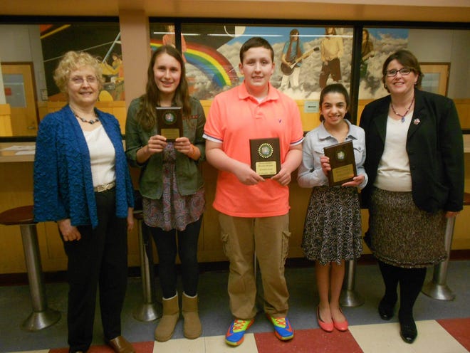 Eighth grade winners Emma Roberts, Nick Kartsounis, and Emily Constan stand with Department Head Karen Blakeslee (left) and Principal Dorothy Flaherty (right) to display their prize plaques. Wicked Local Photo / Anna Burgess