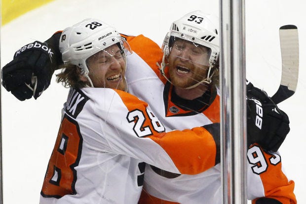 Philadelphia Flyers' Claude Giroux (28) celebrates his goal with teammate Jakub Voracek (93) in the third period of an NHL hockey game against the Pittsburgh Penguins in Pittsburgh, Saturday, April 12, 2014. The Flyers won in overtime, 4-3. (AP Photo/Gene J. Puskar)